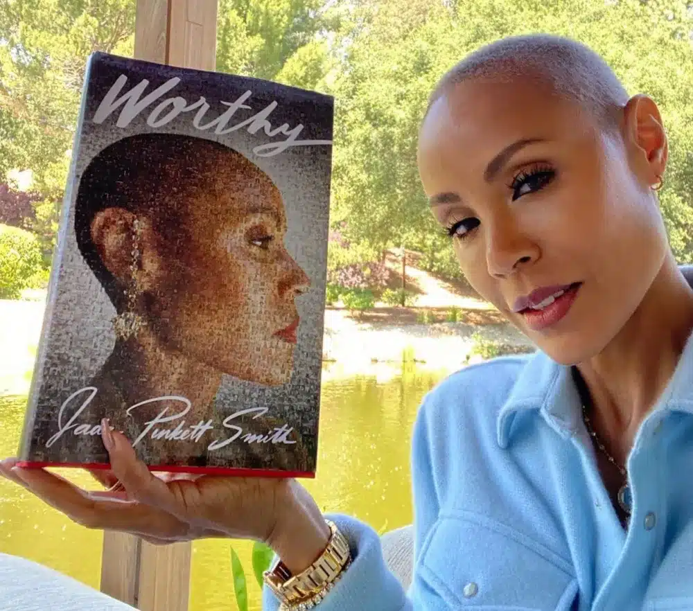 Jada Pinkett Smith holds up a copy of her book, "Worthy"