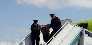 Drunk airline passenger being taken off plane - Depositphotos