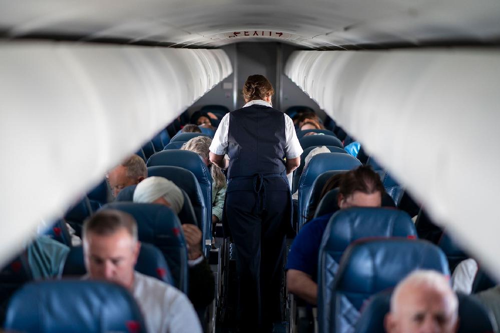 Flight Attendant & passengers (Kent Nishimura-Los Angeles Times-Getty Images) 