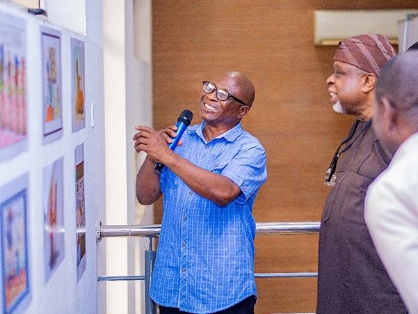 CARTAN President Dada Adekola talks through cartoons on display to one of Nigerias foremost artist and painter Kolade Oshinowo - Cartoon, Animation, and Comic Art Festival