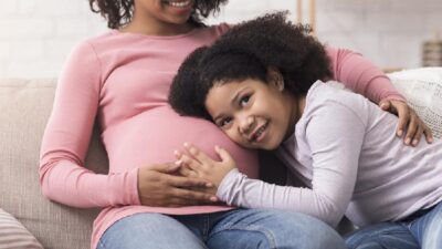 Pregnant black mom and young daughter - Depositphotos