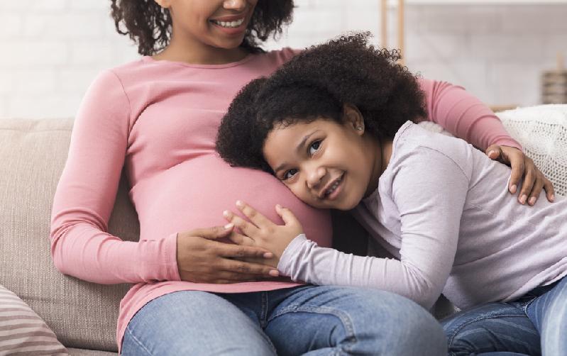 Pregnant black mom and young daughter - Depositphotos