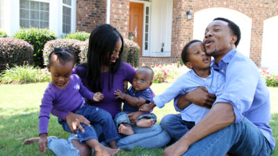 Black wealth - mother, Father, kids in front of house - Depositphotos
