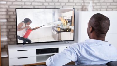 Man watching flat screen TV - Depositphotos