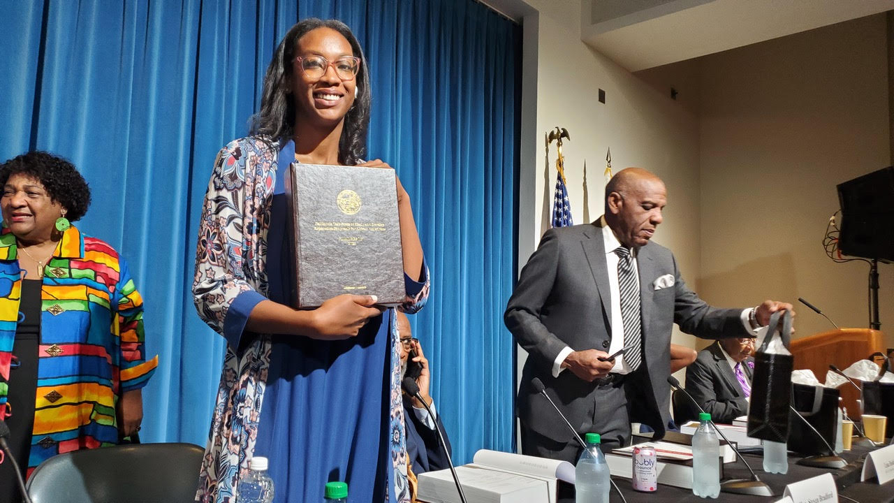 Los Angeles-based attorney and former chairperson Kamilah Moore, Esq. of the California Reparations Task Force holds he 1075-page report submitted to the legislature on June 28, 2023. The report contains 100-plus reparations recommendations. CBM photo by Antonio Ray Harvey.