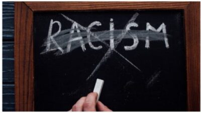 The word "RACISM" written on a chalkboard