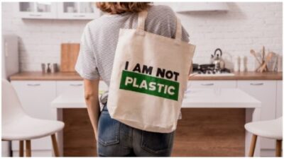 Young girl holding a cloth bag. At the kitchen. I am not plastic.