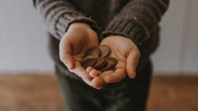 Man's hands with coins - via Unsplash