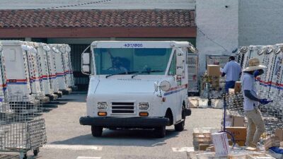 Postal workers and trucks (Kyle Grillot-AFP-Getty Images-File via CNN Newsource)