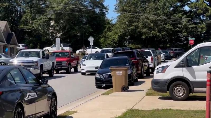 Apalachee High School shooting: suspect in custody per sheriff // A line of cars park about half a mile from Apalachee High School.