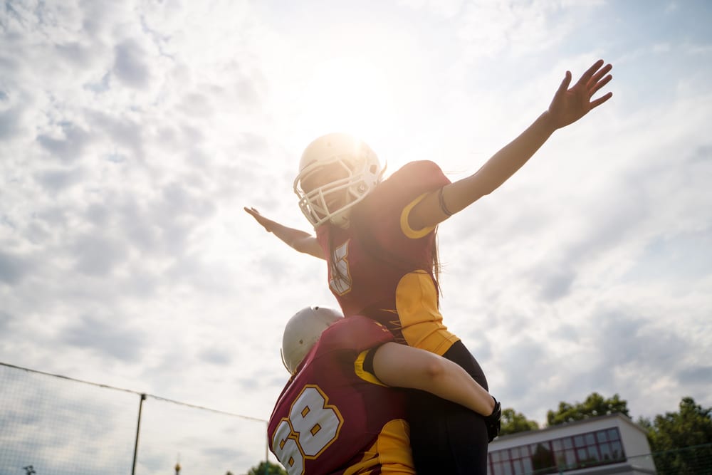 Photo of two American football woman athletes wearing helmet