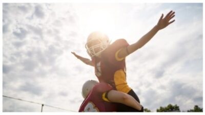 Photo of two American football woman athletes wearing helmet
