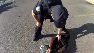Phoenix cop stands over Tyron McAlpin (Phoenix Police Department via KNXV via CNN Newsource)