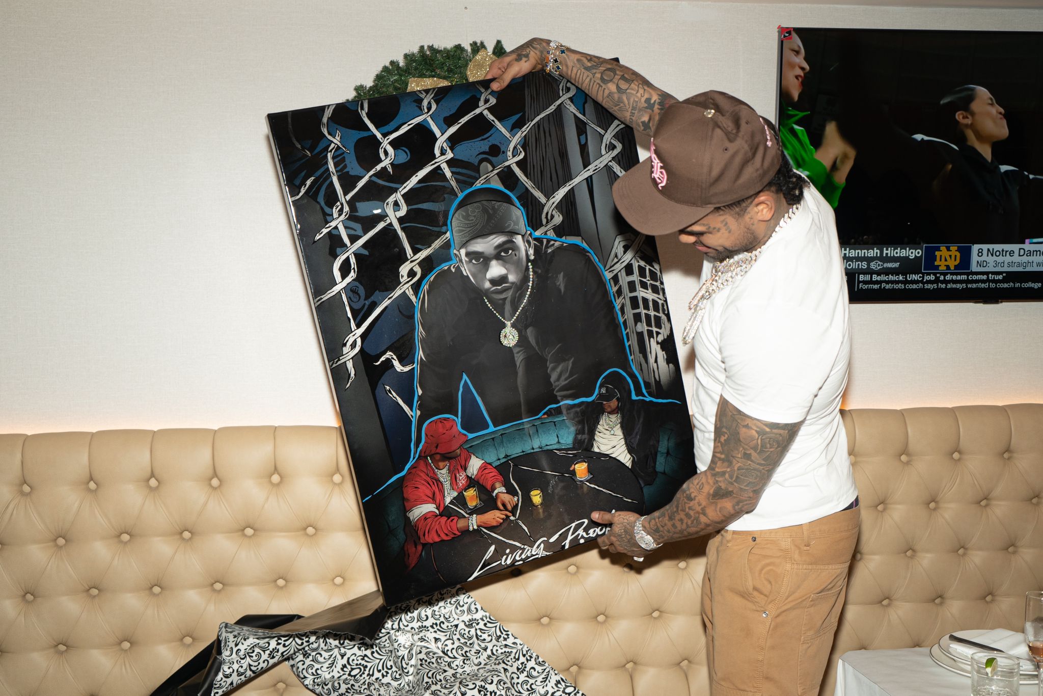 Dave East Receives Art Piece Honoring Late Rapper Kiing Shooter // Dave East with Splat Werkz art (photo by Melissa Nyomi Stoll)