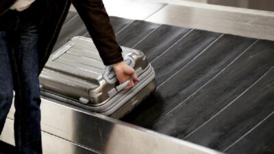Man getting luggage from carousel - Depositphotos
