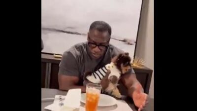 Shannon Sharpe and doggie at dinner table - screenshot