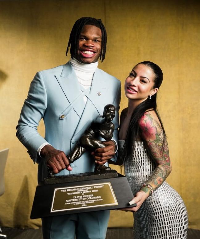 Travis Hunter Wins Heisman, Criticism of Girlfriend Clouds Moment // Travis Hunter and Leanna Lenee with Heisman Trophy - via Instagram