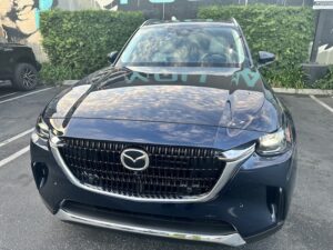 a dark blue cx-90 featuring the cross hatch grille