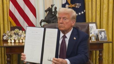 Donald Trump showing signed executive order - screenshot