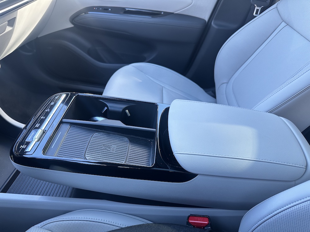pictured is a center console with a flat space for phone charging and two cup holders