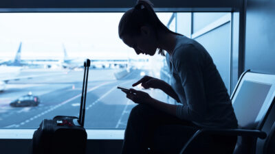 person at airport looking a smartphone