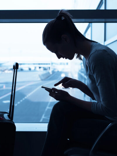 person at airport looking a smartphone