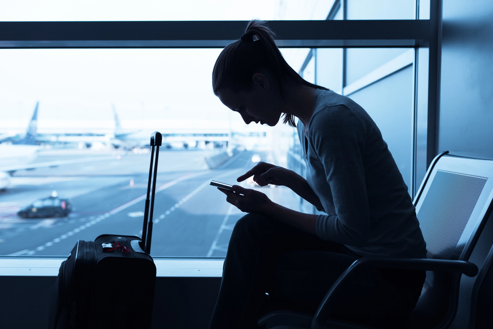 person at airport looking a smartphone