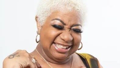 Luenell poses with signature flair in a playful promo portrait