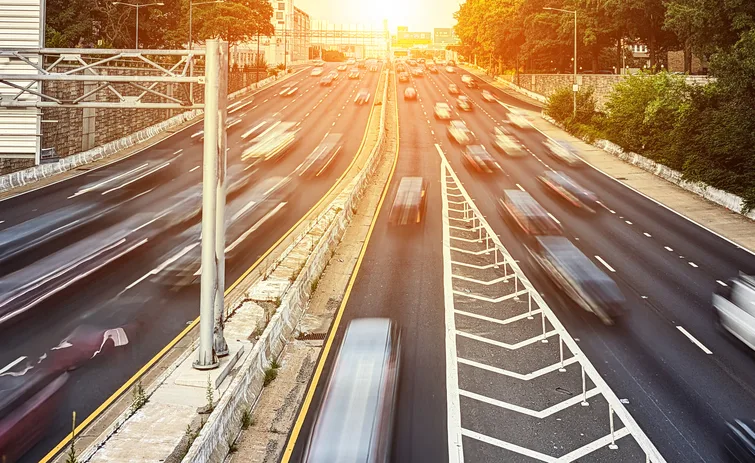 Cars driving down the highway with motion blur effect through rush hour traffic with sunlight background stock photo