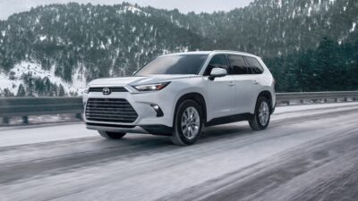 white suv on the road. snow in the background