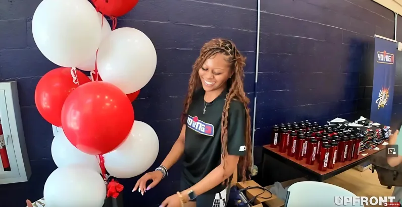 A young lady is seen setting up items at at the YOUNG3 event - screenshot