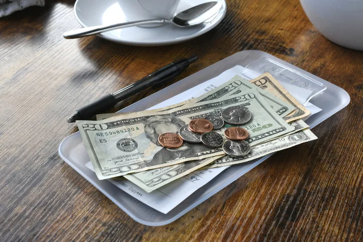 Paying for your bill tab at a restaurant cafe with cash money