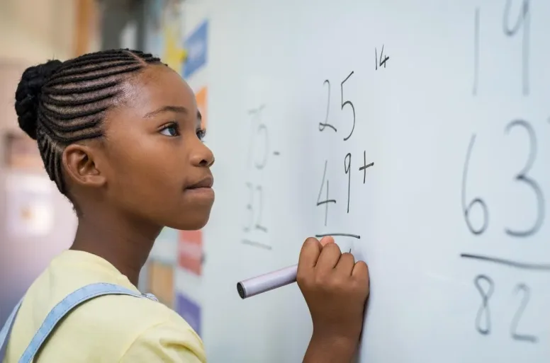 African American student working out computation - via California Black Media/Shutterstock