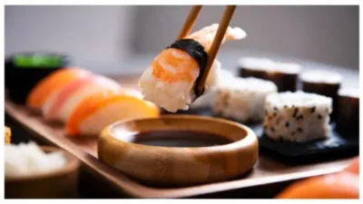 Chopstick with nigiri sushi piece stock photo