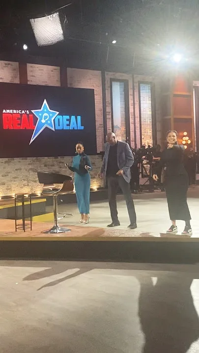 Cast members on stage with &ldquo;America&rsquo;s Real Deal&rdquo; logo in background
