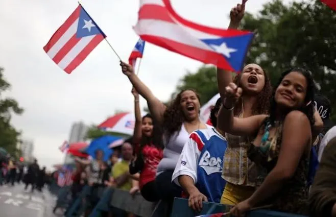 Revelers in NYC&rsquo;s Spanish Harlem wave Puerto Rican flags - via Mario TamaGetty Images