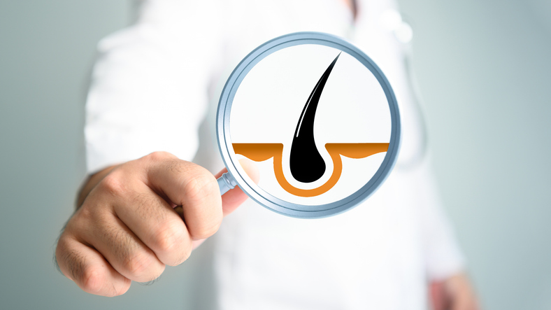 Magnifying glass on researcher hand with hair pores background