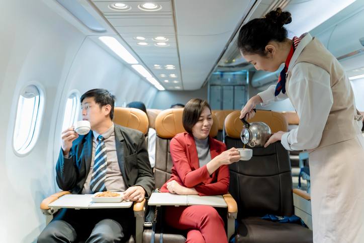 Flight attendant pouring hot coffee 
