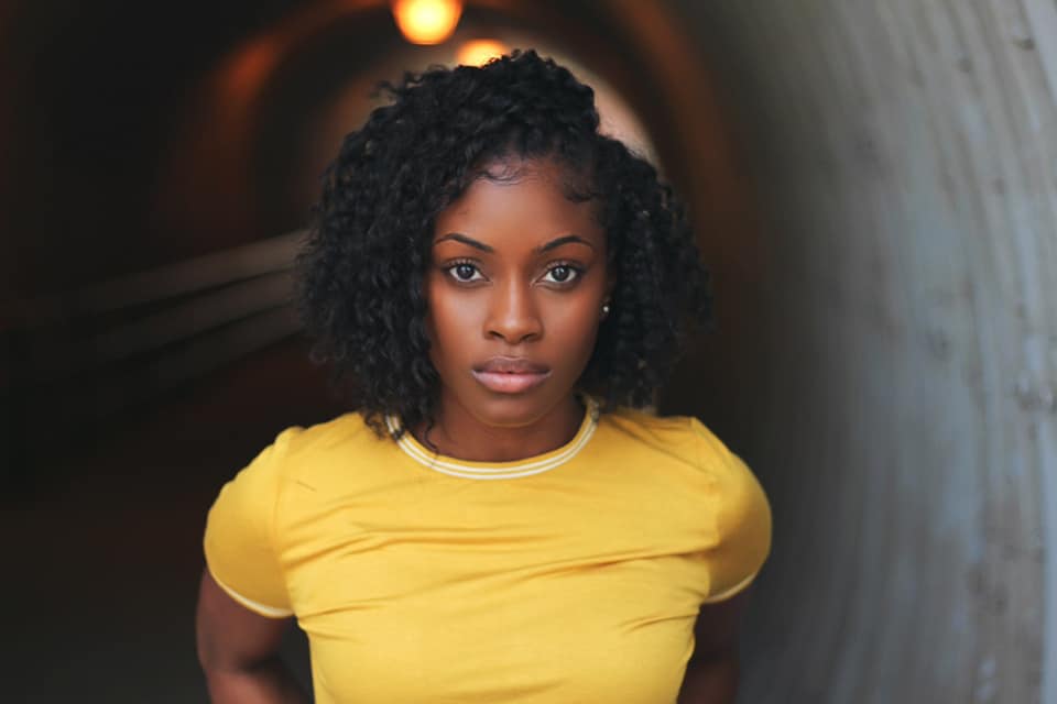 Jasmine Sargent standing in a tunnel wearing a mustard top.