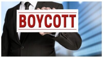 Boycott shield is held by businessman stock photo