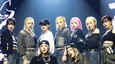 An image of a K-Pop group performing onstage in hip-hop-style outfits with exaggerated streetwear and 90s-inspired fashion under bright lights - via GrokAI