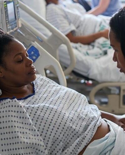 A maternity ward scene showing a Black woman being comforted by a nurse - via eurAI