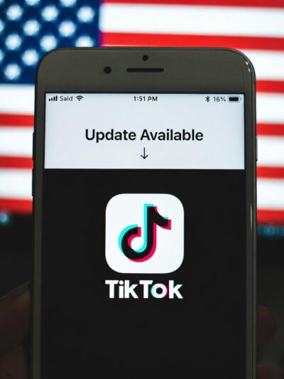 A smartphone screen showing the TikTok app updating, with a US flag - via eurAI