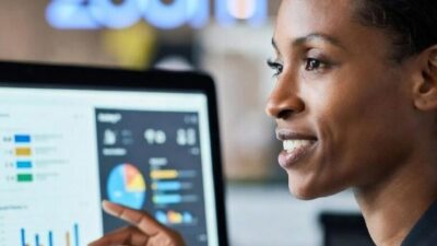A solo business owner presenting a pitch or design on a computer screen, with AI or data visualizations displayed - via eurAI