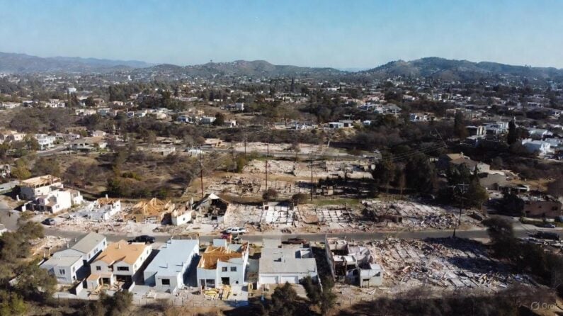 A wide aerial shot of Altadena’s westside burn scar one year after the Eaton Fire, with partial rebuilding, fire-damaged lots, and community signs - via GrokAI