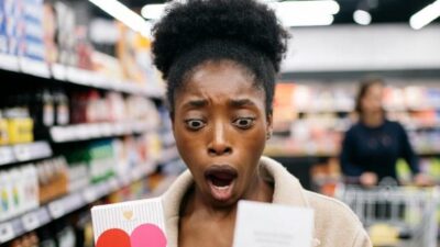 A shopper at checkout holding a small box of Valentine&rsquo;s Day chocolates experiencing a 'WHOA' moment - via eurAI