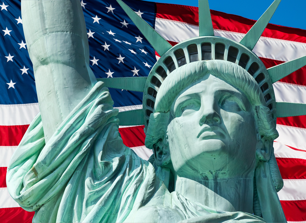 American flag in background with Statue of Liberty