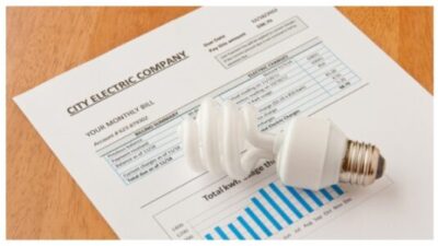 Energy efficient CFL bulb on electric bill. Energy efficient house concept.