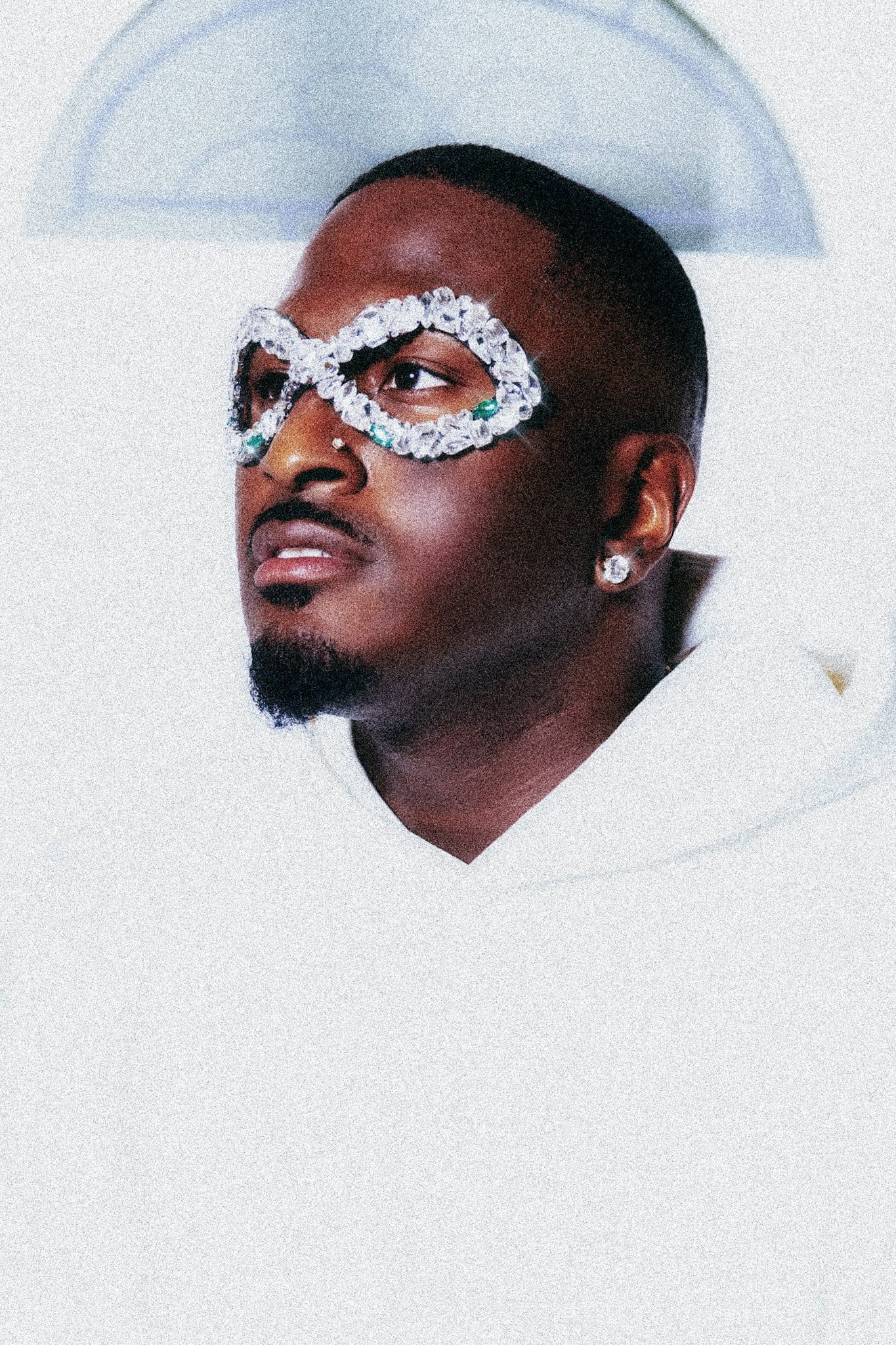 Ben Reilly wearing crystal embellished glasses looking upward