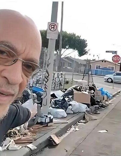 Earl Ofari Hutchinson points to garbage dumping on South LA street corner - screenshot